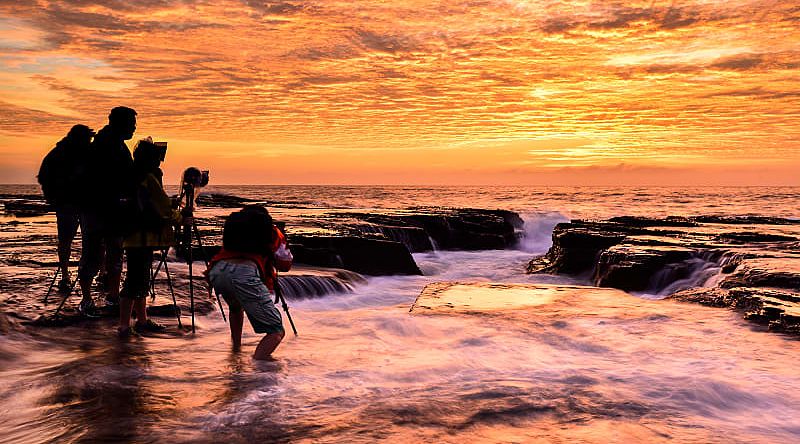 Photographers capturing sunrise on the North Narrabeen coast near Sydney, Australia