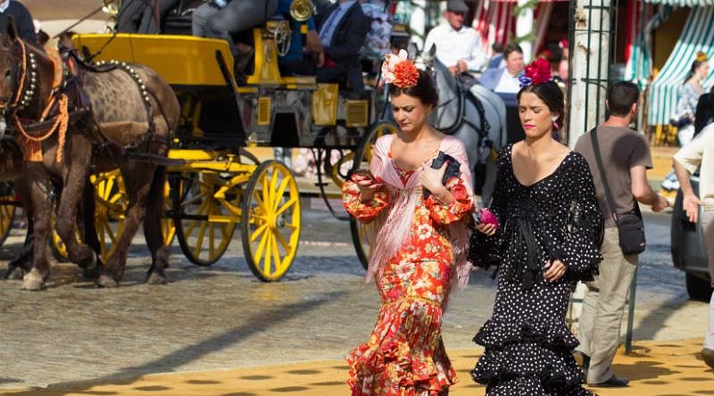 Women wearing traditional dresses in Seville, Spain.