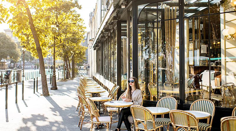 Woman sitting at an outdoor cafe in Paris, France