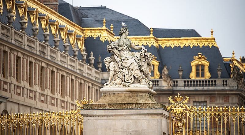 Statue and ornate architecture of Versailles in France.