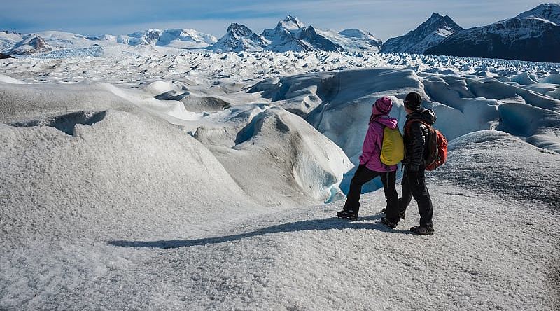 Couple admiring the stunning view of Perito Moreno Glacier in Argentina Couple admiring the stunning view of Perito Moreno Glacier in Argentina
