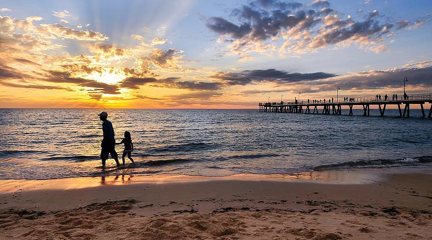 Father and daughter walking on the beach at sunset in Adelaide