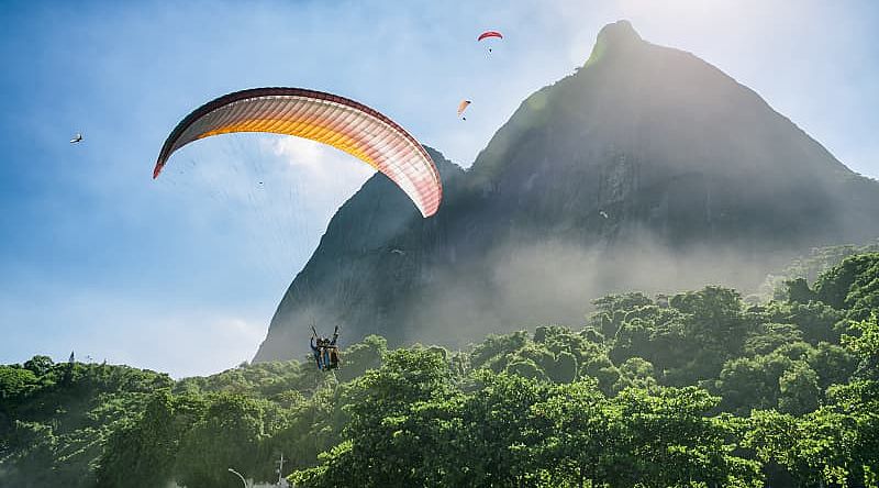 Couple on a romantic paragliding flight over the coast of Brazil