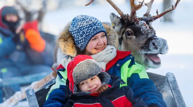 Family on reindeer safari in Finland.