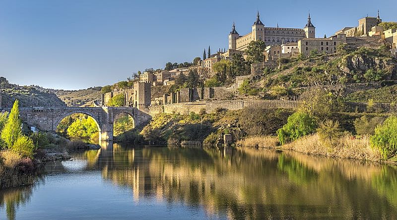 Bridge and river in Toledo, Spain with the Alcazar fortification in background Bridge and river in Toledo, Spain with the Alcazar fortification in background