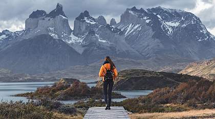 Hiker walking toward Torres del Paine peaks in Patagonia, Chile.