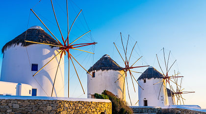 Famous windmills of Mykonos town at romantic sunset, Greece