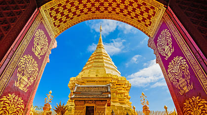 Golden temple framed by ornate archway at Wat Phra That Doi Duthep in Chiang Mai, Thailand