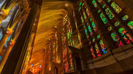 Afternoon light streaming through the stained glass windows of La Sagrada Familia in Barcelona, Spain