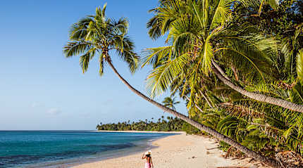 Woman walking the long stretch of beach on Kadavu Isand, Fiji