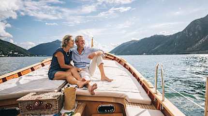 Luxury senior couple cruising on a private boat on a lake in Switzerland