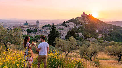 Couple Toasting Wineglasses at sunset in Assisi, Italy