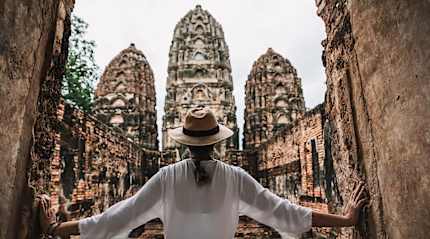 raveler explores the ancient Khmer-style temple ruins of Wat Si Sawai in Sukhothai, Thailand.