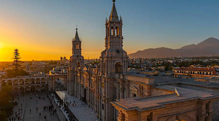 Arequipa Cathedral at sunset, historic landmark in Peru with volcanic mountains in the background