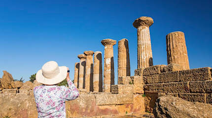 Senior woman taking a photograph at the Valley of the Temples in Sicily, Italy
