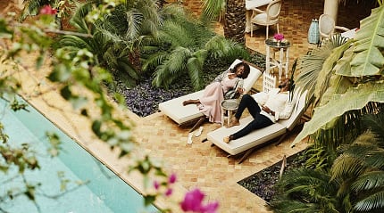 Couple at lounging by the pool at luxury riad in Marrakech, Morocco