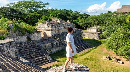 Woman looking out at Mayan ruins in Yucatan, Mexico
