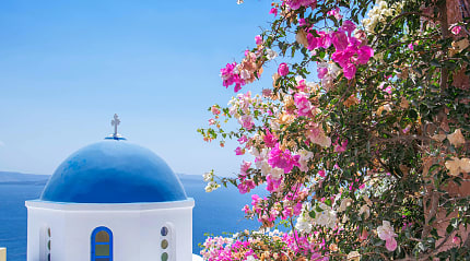 Blue dome church with spring flowers on Santorini island, Greece