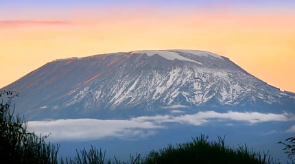Mount Kilimanjaro’s Kibo peak glowing under the light of dawn.