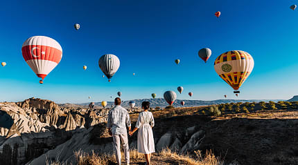 Couple watching the hot air balloons launch in Cappadocia, Turkey