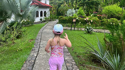 Young girl walking along a stone path surrounded by lush tropical greenery at a luxury resort in Costa Rica