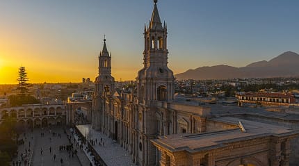 Arequipa Cathedral at sunset, historic landmark in Peru with volcanic mountains in the background