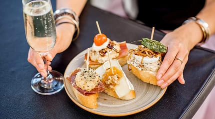 Plate of traditional Spanish pintxos with a glass of cava in San Sebastián, Spain