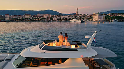 Couple on a luxury yacht admiring the Split skyline during dusk in Croatia