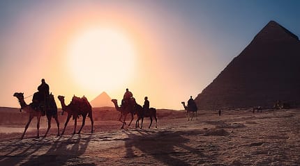 People riding camels at the Pyramids at Giza, Egypt