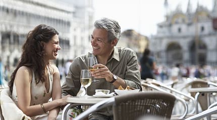 Couple drinking wine and dining al fresco in Venice, Italy