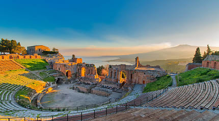 Ancient theatre of Taormina in Sicily with Mount Etna in the background at sunset