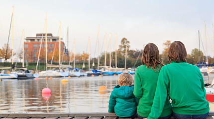 Family sitting on pier in Stockholm, Sweden.
