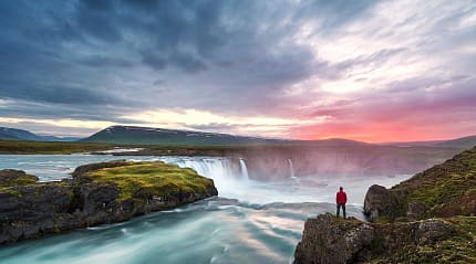 Man overlooking Godafoss waterfall in northern Iceland
