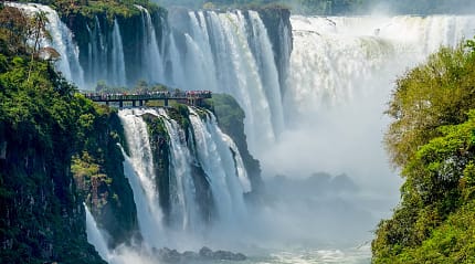 Travelers viewing The Devil's Throat from a platform on the Argentinian side of Iguazu Falls