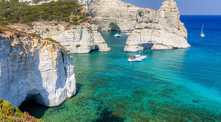 Cliffiside waters with boats at Kleftiko Beach in Milos, Greece