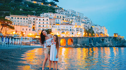 Mother and daughter on the beach at dusk in Amalfi, Italy