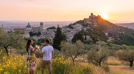 Couple Toasting Wineglasses at sunset in Assisi, Italy