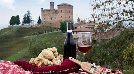 White Pidemont truffles and glass of wine with castle in the background in Piedmont, Italy