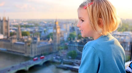Little girl at sunset observing the Westminster Abbey in London