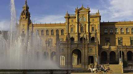 Plaza de España in Seville, Spain, featuring a grand fountain, historic architecture, and a horse-drawn carriage