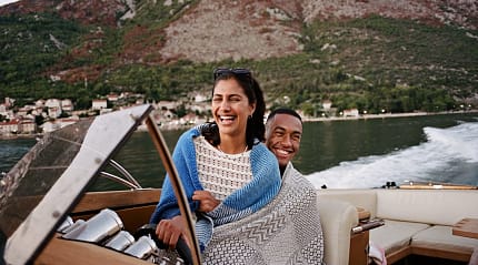 Couple enjoying a boat ride across the Bay of Kotor near Kotor, Montenegro