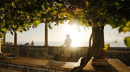 Traveler enjoying sunrise from a scenic miradouro overlooking Lisbon, Portugal.
