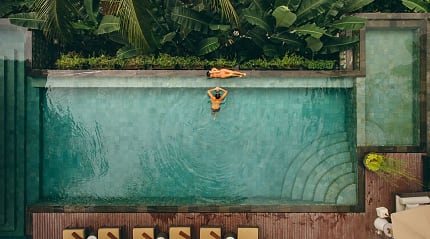 Tropical poolside retreat surrounded by lush greenery and serene vibes.