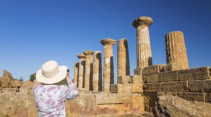Senior woman taking a photograph at the Valley of the Temples in Sicily, Italy