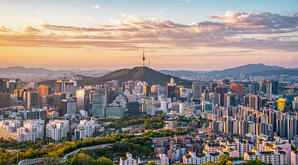 Panoramic view of Seoul city skyline with Namsan Seoul Tower at sunset.