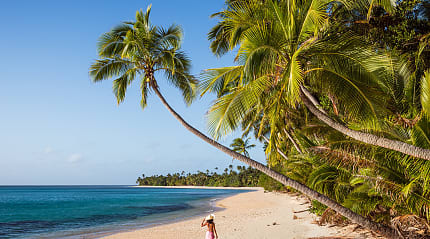 Woman walking the long stretch of beach on Kadavu Isand, Fiji