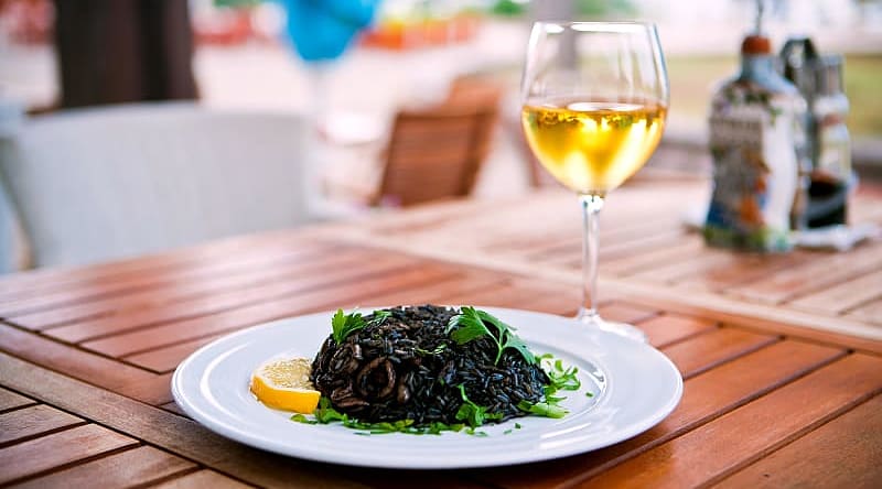 Black risotto with seafood and glass of white wine Black risotto with seafood and glass of white wine