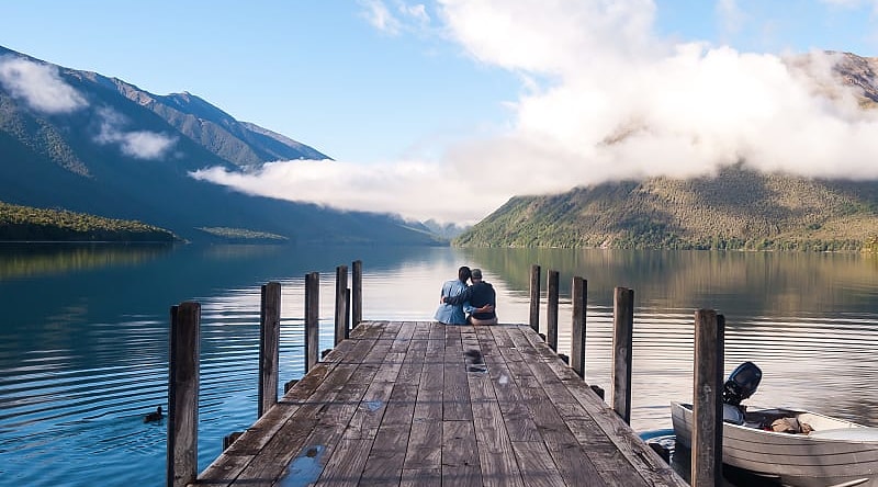 Nelson Lake National Park, New Zealand Couple sitting on the pier at Nelson Lake National Park