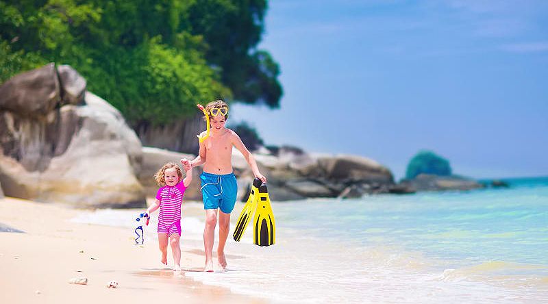 Young brother and sister running on the beach in Fiji Young brother and sister running on the beach in Fiji