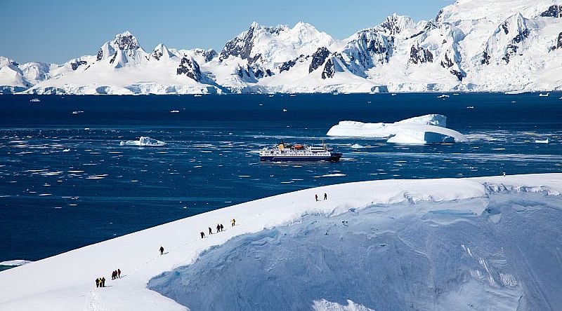 Antarctica Cruise and Excursion Tourists hiking on glacier during an excursion in Antarctica